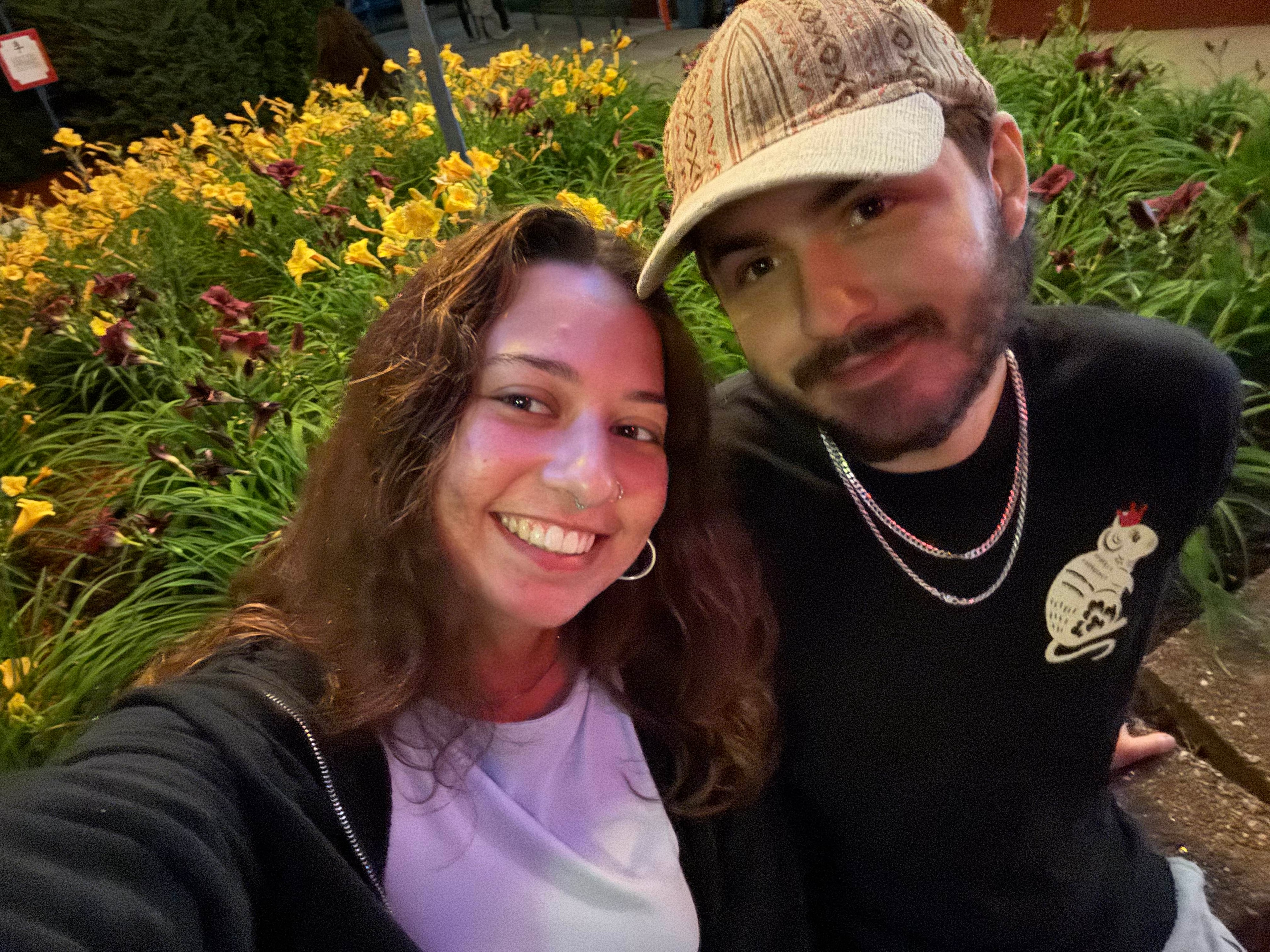 Couple smiling by flowers at night